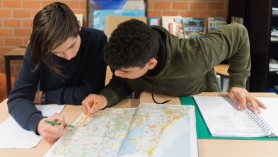 ISK-leerlingen bekijken een atlas